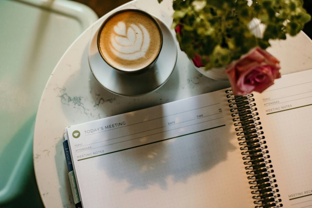 flat‑lay of notebook with ‘Joy’ handwritten and coffee cup for inspiration