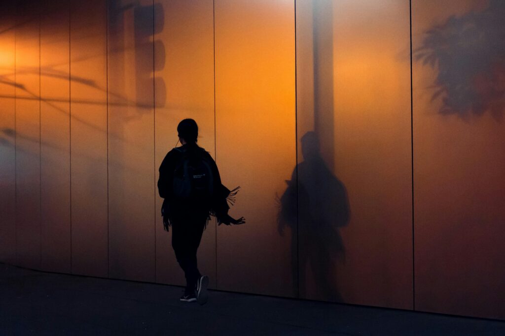  person tying running shoes on city sidewalk at dawn for everyday motivation