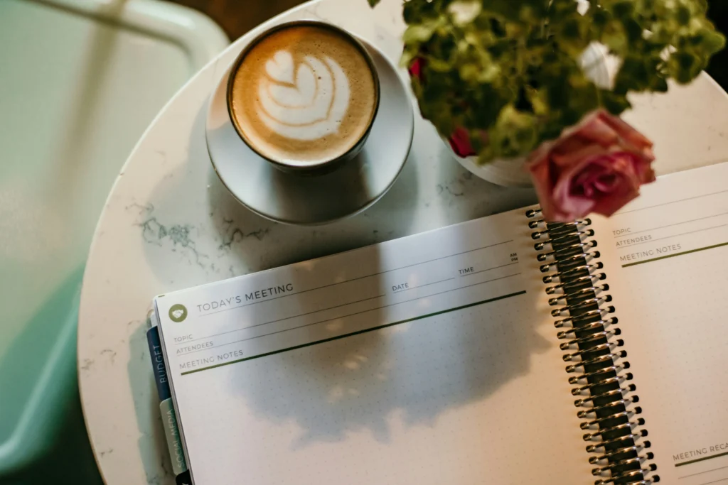  flat‑lay of notebook with ‘Joy’ handwritten and coffee cup for inspiration