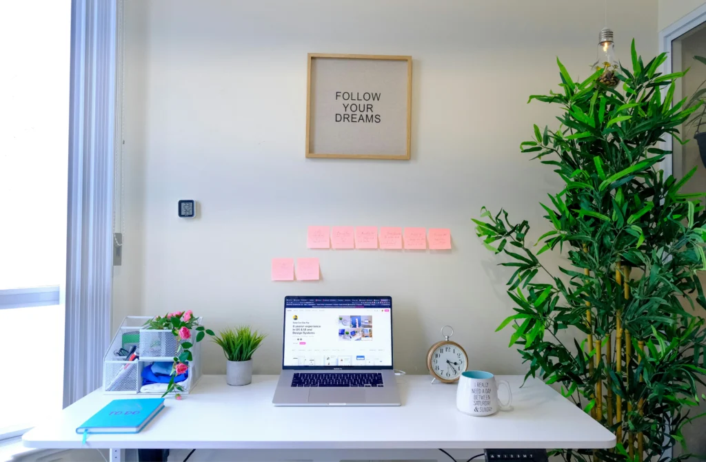 Flat lay of a clean workspace with a sticky note displaying a motivational success quote.
